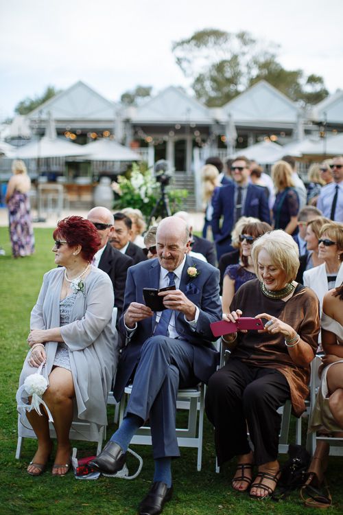 Front-row guests smiling as the ceremony begins