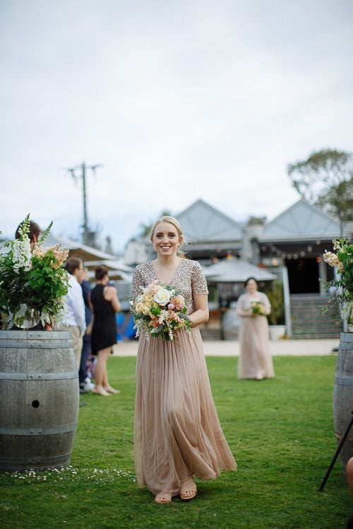 Bridesmaids processing past the venue under festoon lights