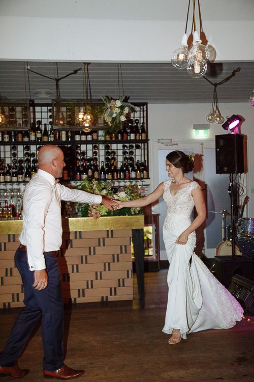 Father and bride stepping onto the dancefloor by the bar