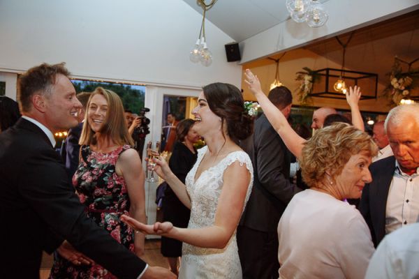 Bride laughing with guests on the packed dancefloor