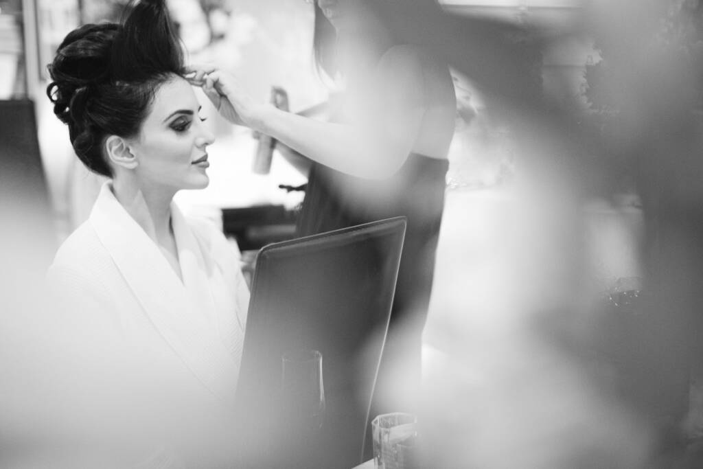 Black-and-white photo of Danielle having her hair styled before the wedding