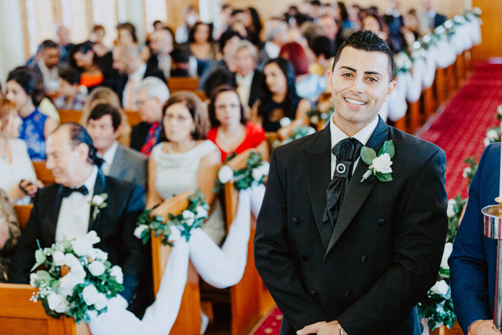 Michael smiles at the front of St Aphrem Syrian Orthodox Church before the ceremony