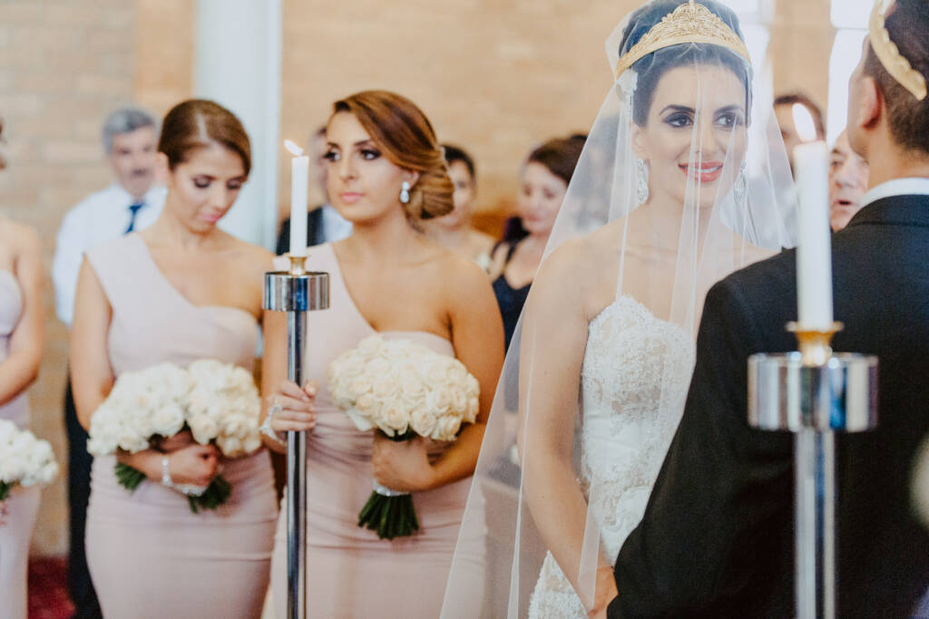 Danielle and Michael wear wedding crowns beside their bridesmaids during the Syrian Orthodox ceremony