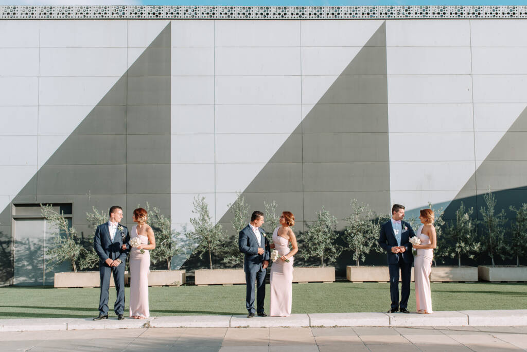 Three bridesmaids and three groomsmen pose against a geometric wall on the Crown Towers Melbourne rooftop