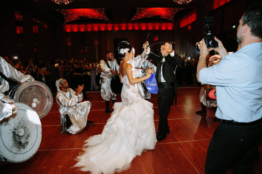 Danielle and Michael dance with swords among zaffe drummers at Palladium
