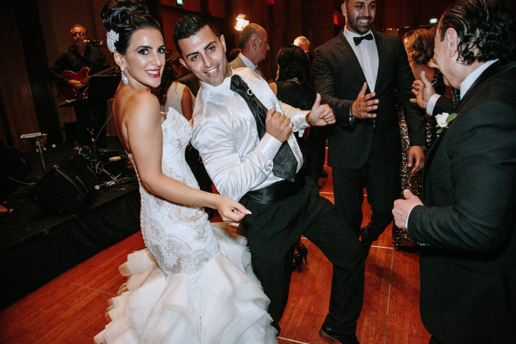 Michael gives two thumbs up beside Danielle as guests dance around them