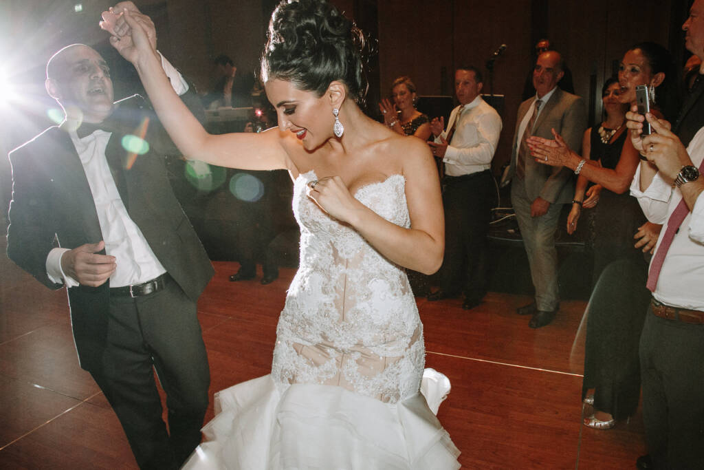 Danielle holds a guest's hand overhead as they dance together at Crown Palladium