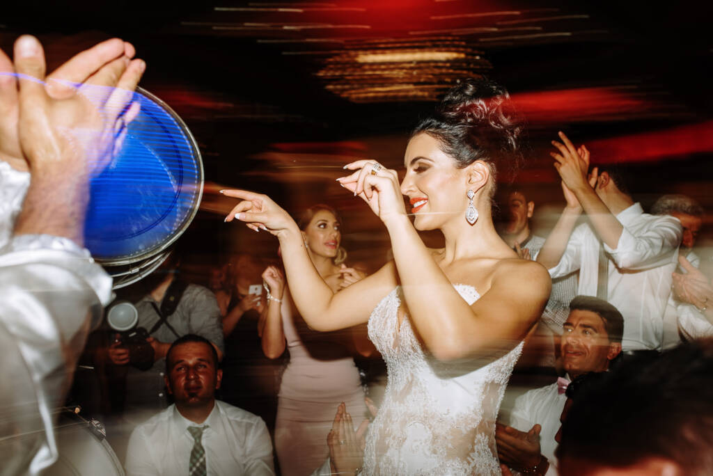 Danielle dances beside an illuminated drum amid reception light trails at Palladium at Crown