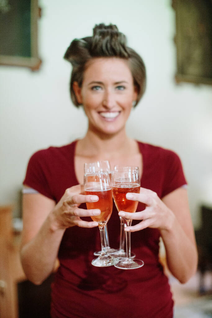 Camilla holds several filled glasses while getting ready at Flowerdale Estate.