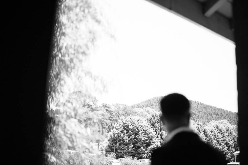 Black-and-white silhouette of Jason looking out towards trees and hills at Flowerdale.