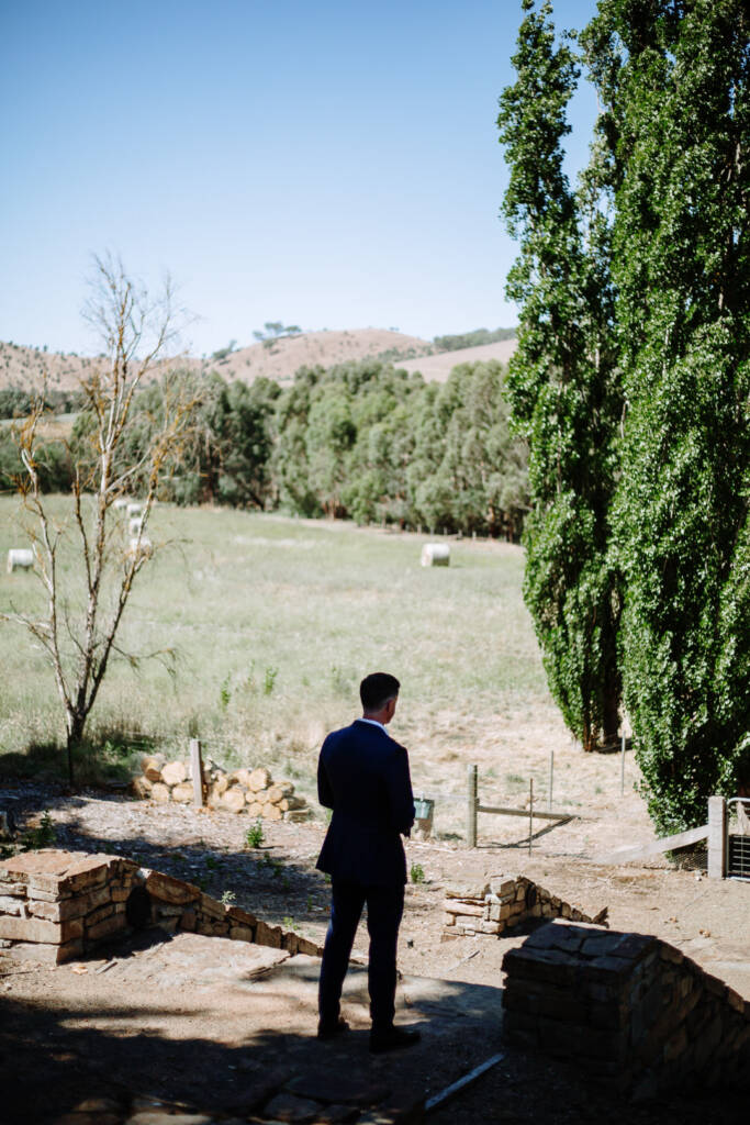 Jason stands on stone steps overlooking the Flowerdale Estate paddocks before the first look.