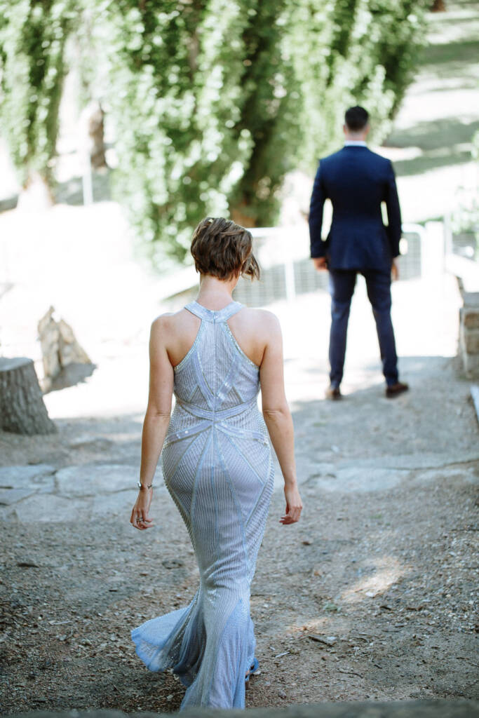 Camilla approaches Jason from behind on stone steps at Flowerdale Estate.