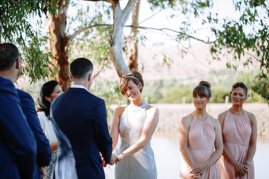 Camilla smiles while holding Jason's hands at their Flowerdale Estate ceremony.
