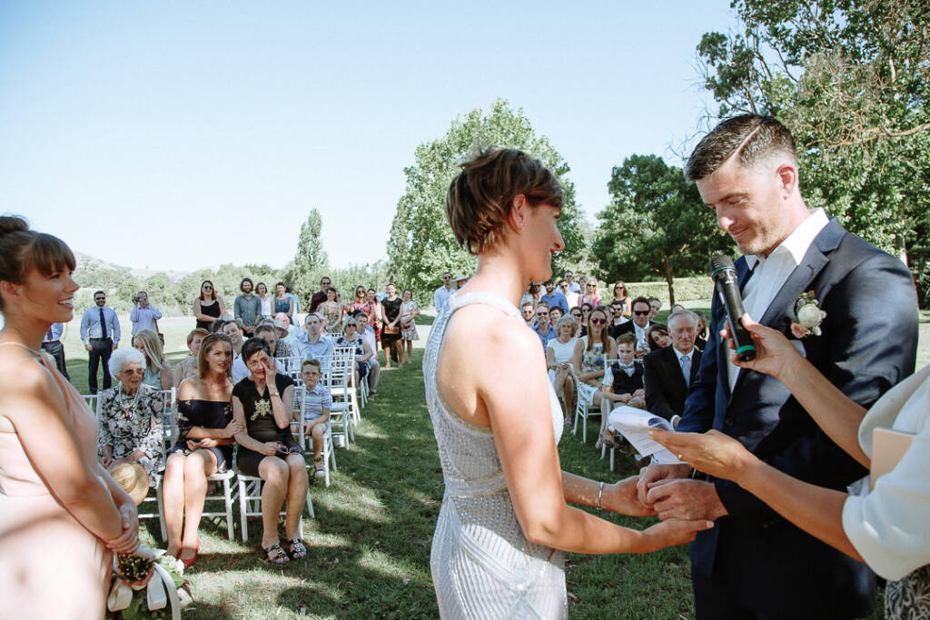 Camilla and Jason hold hands beside the celebrant and microphone at Flowerdale Estate.