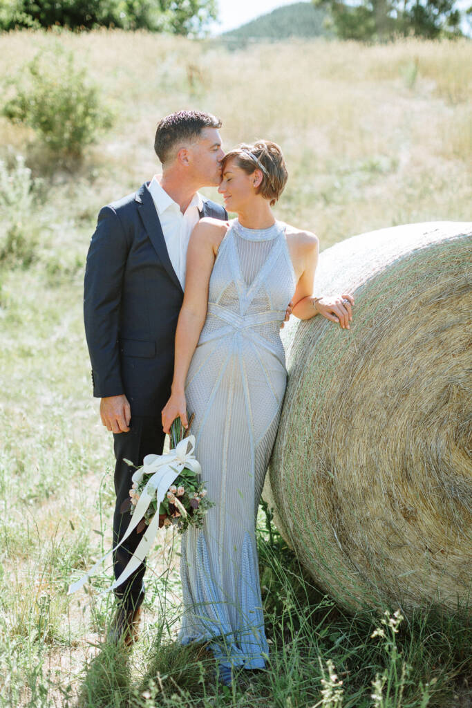 Jason kisses Camilla's forehead beside a hay bale at Flowerdale.