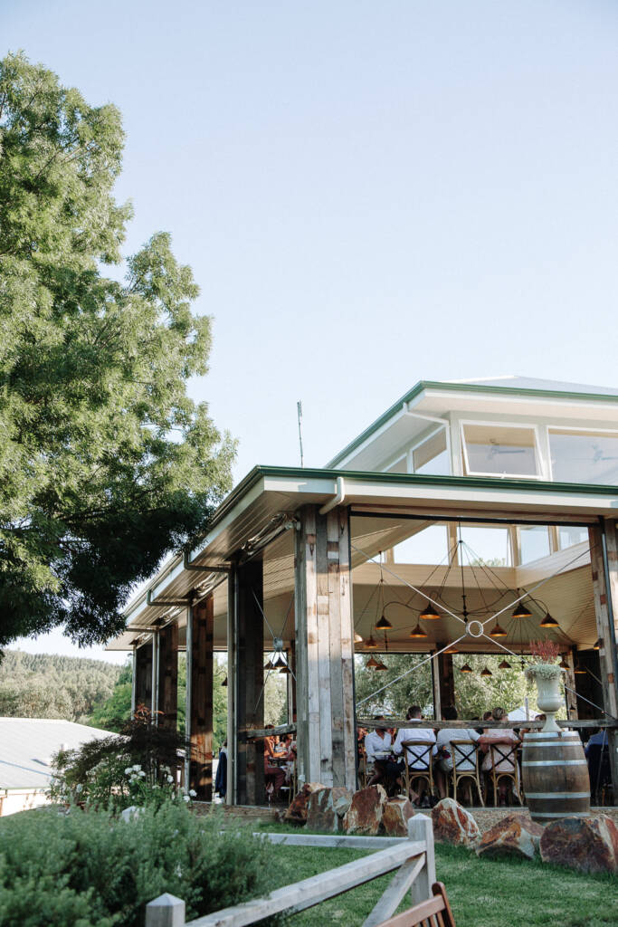 Guests gather inside the timber-post reception pavilion at Flowerdale Estate.