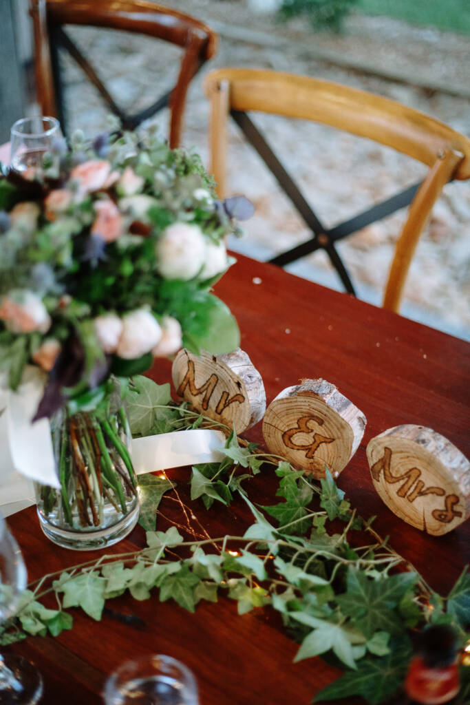 Wedding bouquet, greenery and wood-slice Mr and Mrs signs on a reception table at Flowerdale.