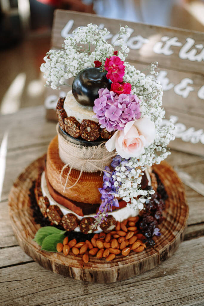 Flowerdale Estate wedding reception display with a tiered cheese-wheel cake and flowers.