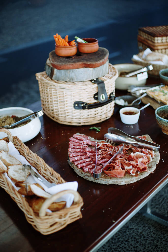 Grazing table with meats, bread, vegetables and wicker risers at Flowerdale Estate.