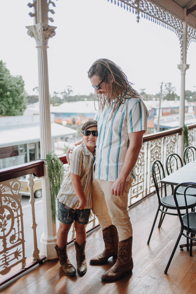Dale and a child smile together in sunglasses and cowboy boots before the wedding.