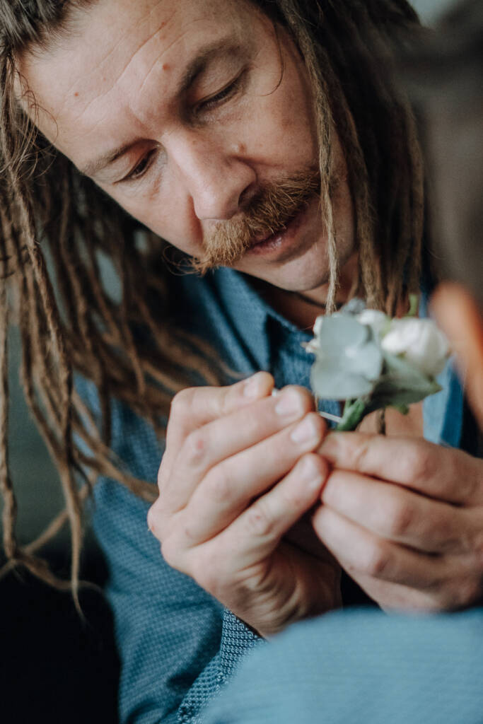 A white-flower boutonniere is pinned to a child’s patterned shirt.