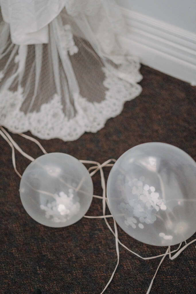 Clear confetti-filled balloons sit beside the lace wedding gown at Royal Hotel Sea Lake.