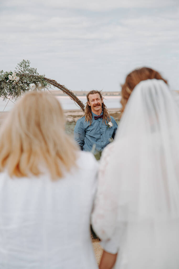Dale waits beside the circular floral arbour for their country wedding at Lake Tyrrell in the Mallee.