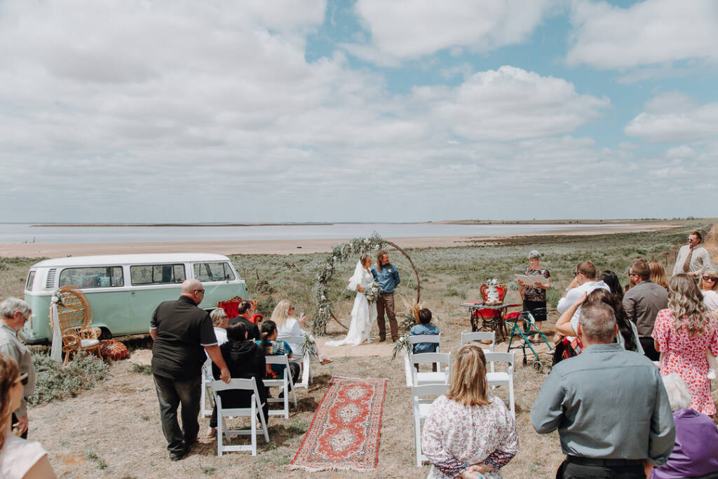 A circular arbour, rug aisle and vintage furniture frame the country wedding at Pink Lake Reserve, Lake Tyrrell.