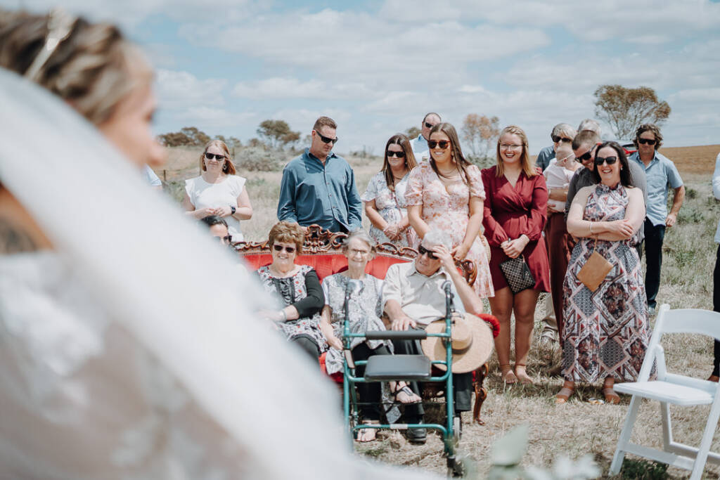 Wedding guests watch from behind a red sofa at Lake Tyrrell.
