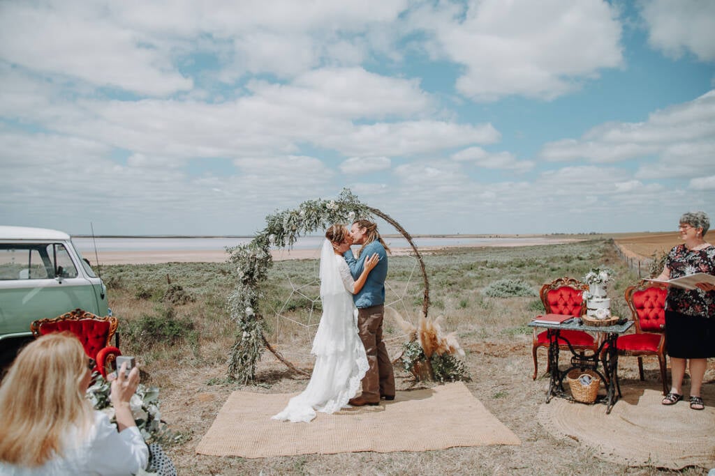Bethany and Dale kiss beneath the circular wedding arbour at Lake Tyrrell.