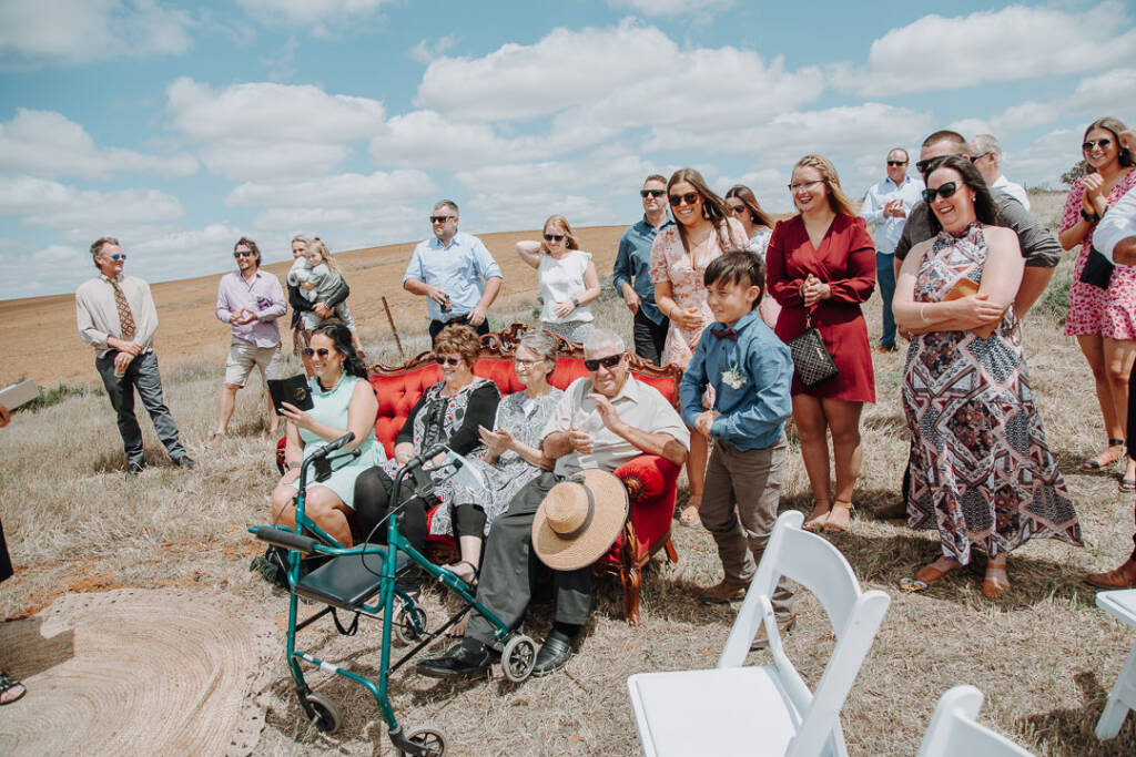 Guests applaud beside the red sofa at Pink Lake Reserve, Lake Tyrrell.
