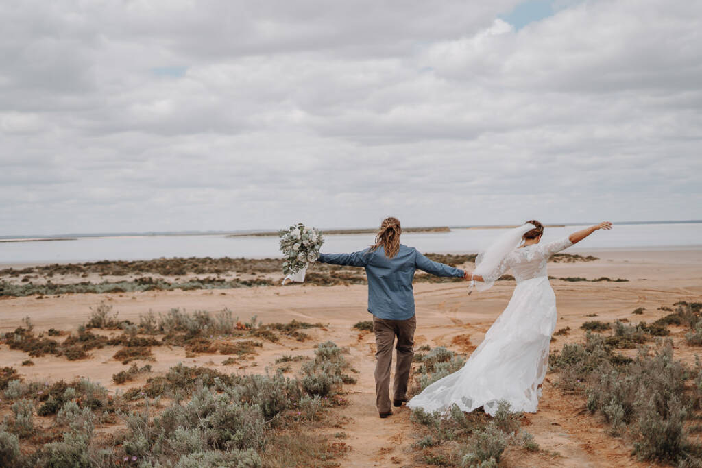 Bethany and Dale stretch their free arms out as they head towards the lake at Pink Lake Reserve, Lake Tyrrell.