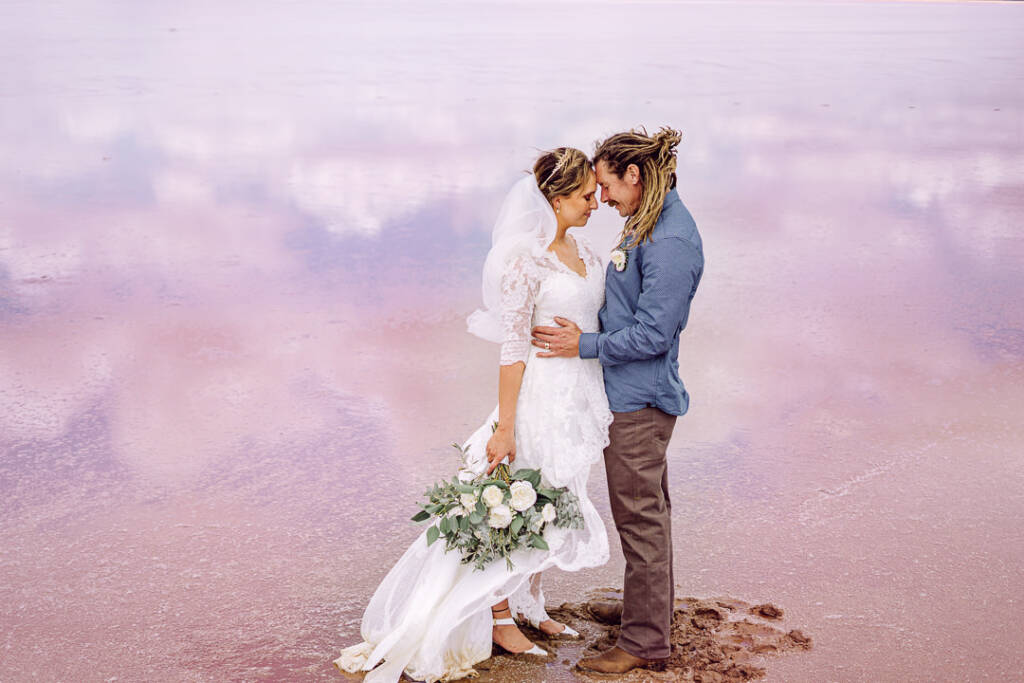 Bethany and Dale touch foreheads above cloud reflections during their Lake Tyrrell wedding photos.