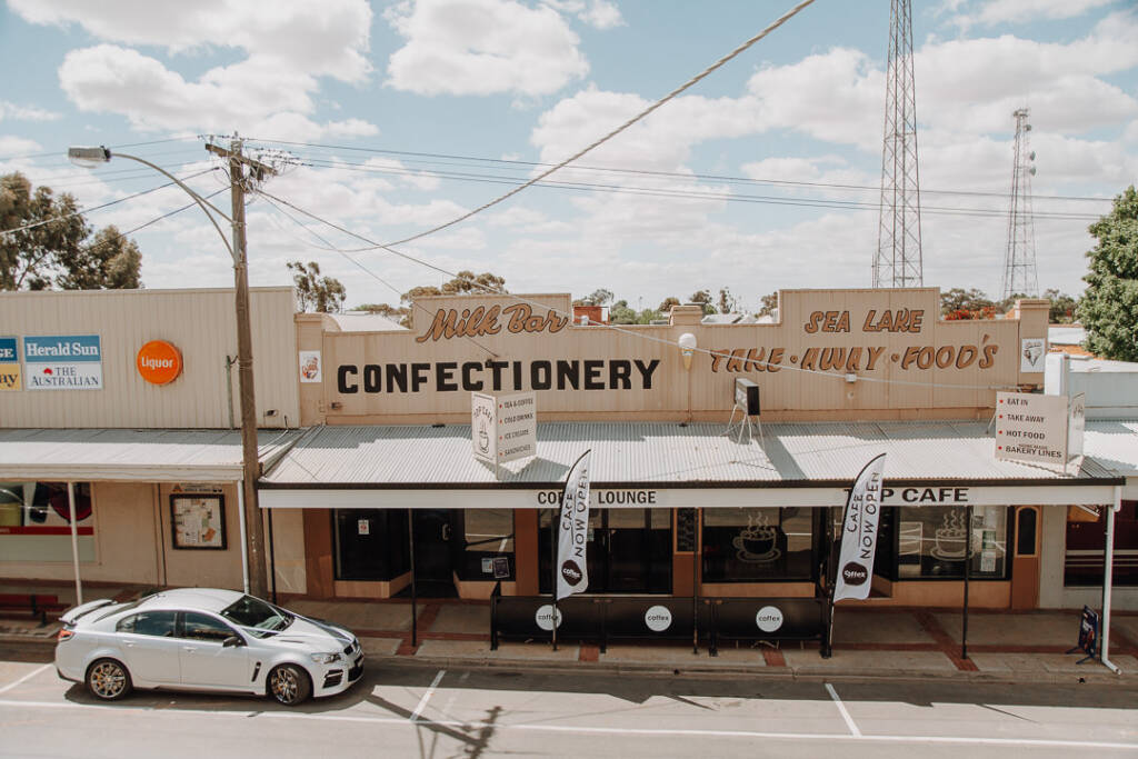 A milk bar and parked car across the street are seen from Royal Hotel Sea Lake.
