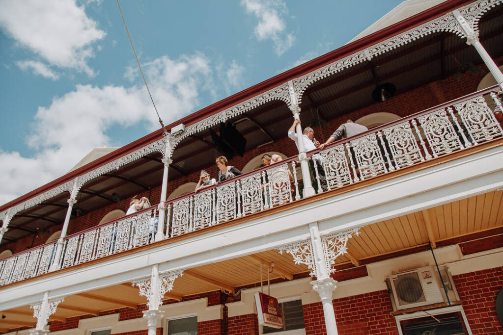 Guests gather on the ornate white balcony at Royal Hotel Sea Lake in the Mallee.