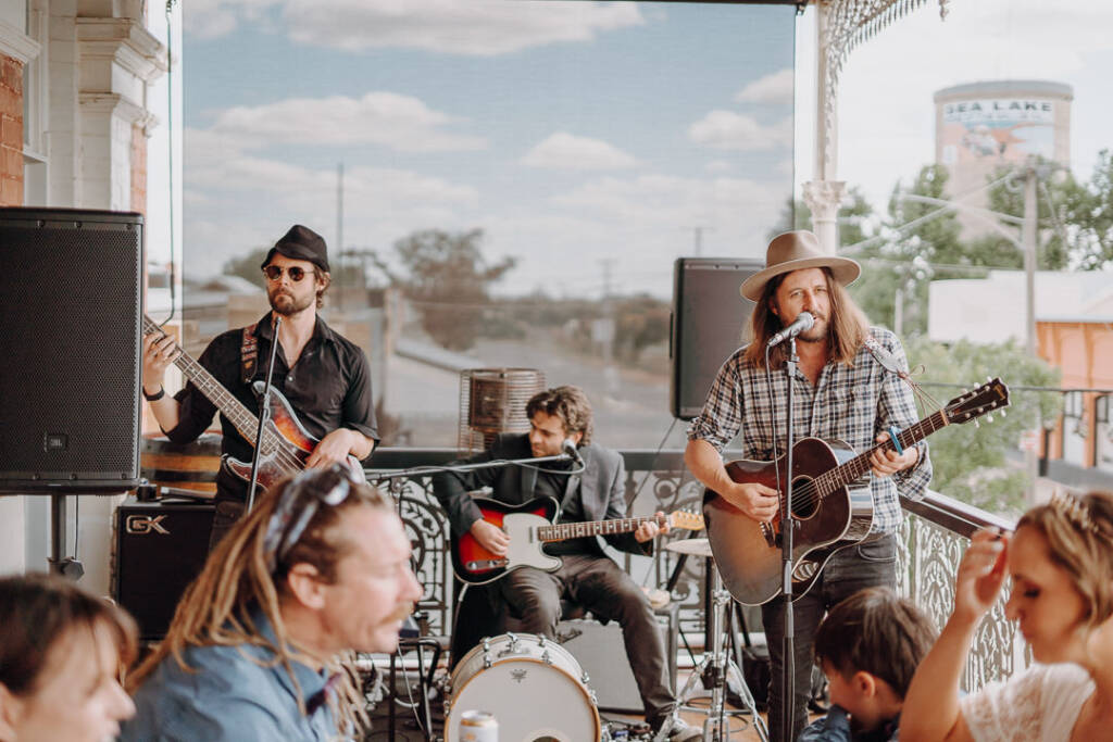 A three-piece band performs on the Royal Hotel’s verandah during the wedding reception.