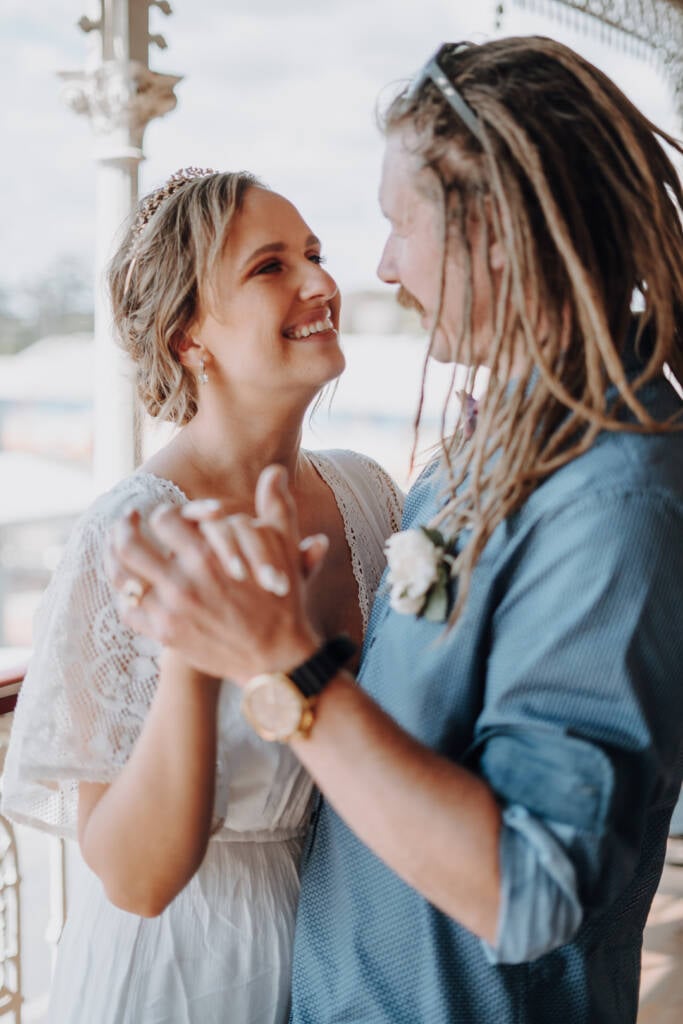 Bethany and Dale smile at each other with hands joined during their reception dance.
