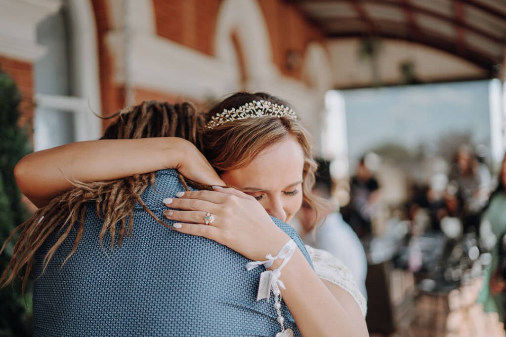Bethany closes her eyes as she hugs Dale, her wedding ring visible on his shoulder.