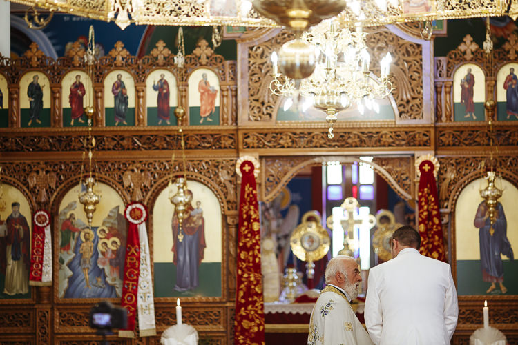 The priest and the groom before the carved gilt iconostasis of Holy Epiphany church in Frankston.