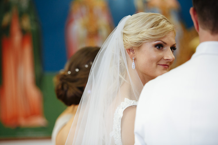 Aggie looks towards Alex with painted icons behind her at Holy Epiphany church in Frankston.