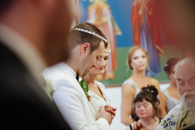 Aggie and Alex wear connected Stefana during their Greek Orthodox Crowning Service.