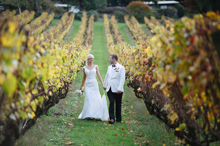 Aggie and Alex hold hands between vineyard rows at Lindenderry on the Mornington Peninsula.