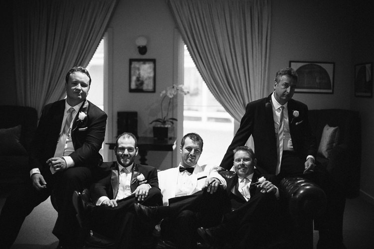 Alex and four groomsmen pose on a leather sofa at Lindenderry Red Hill.