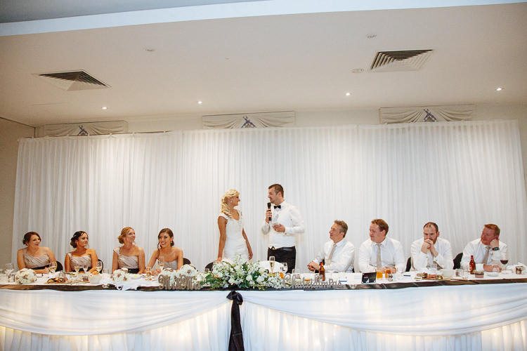 Alex gives a speech beside Aggie at the flower-lined bridal table at Lancemore Lindenderry Red Hill.