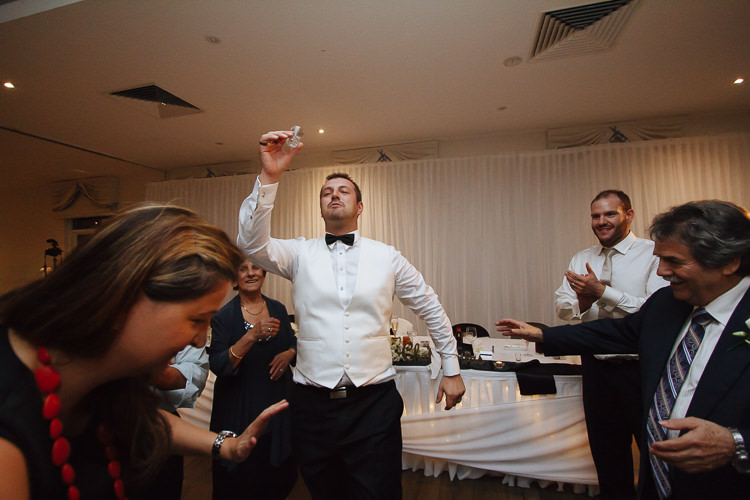 Alex raises a small glass while dancing among applauding guests at Lindenderry Red Hill.