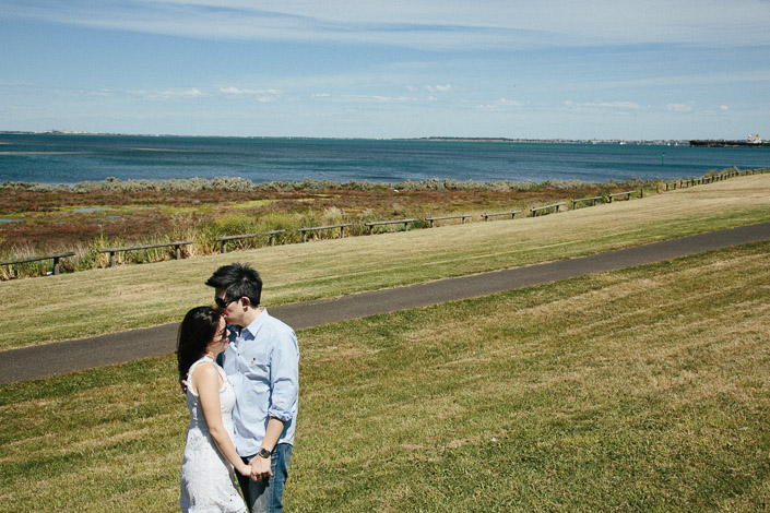 A quiet kiss on the grassy rise above Corio Bay, the path curving away behind
