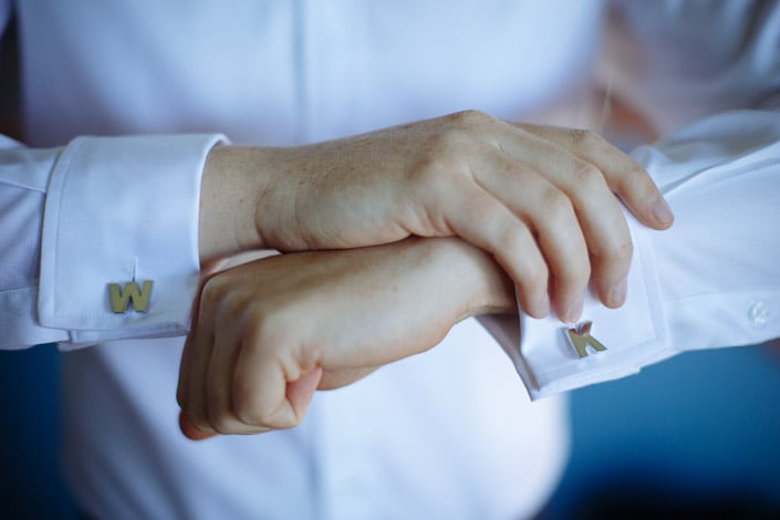 Initial cufflinks W and K crossed at the wrists