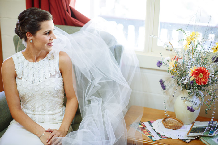 Seated by the gerbera vase, beaded bodice catching the window light