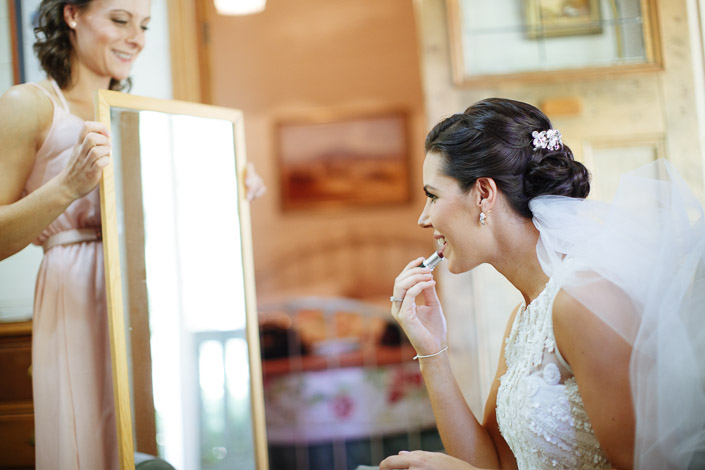 Lipstick on while a bridesmaid steadies the freestanding mirror