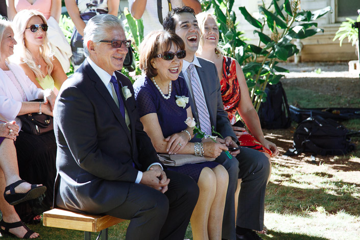 Front-row laughter in sunglasses and pearls as the vows begin